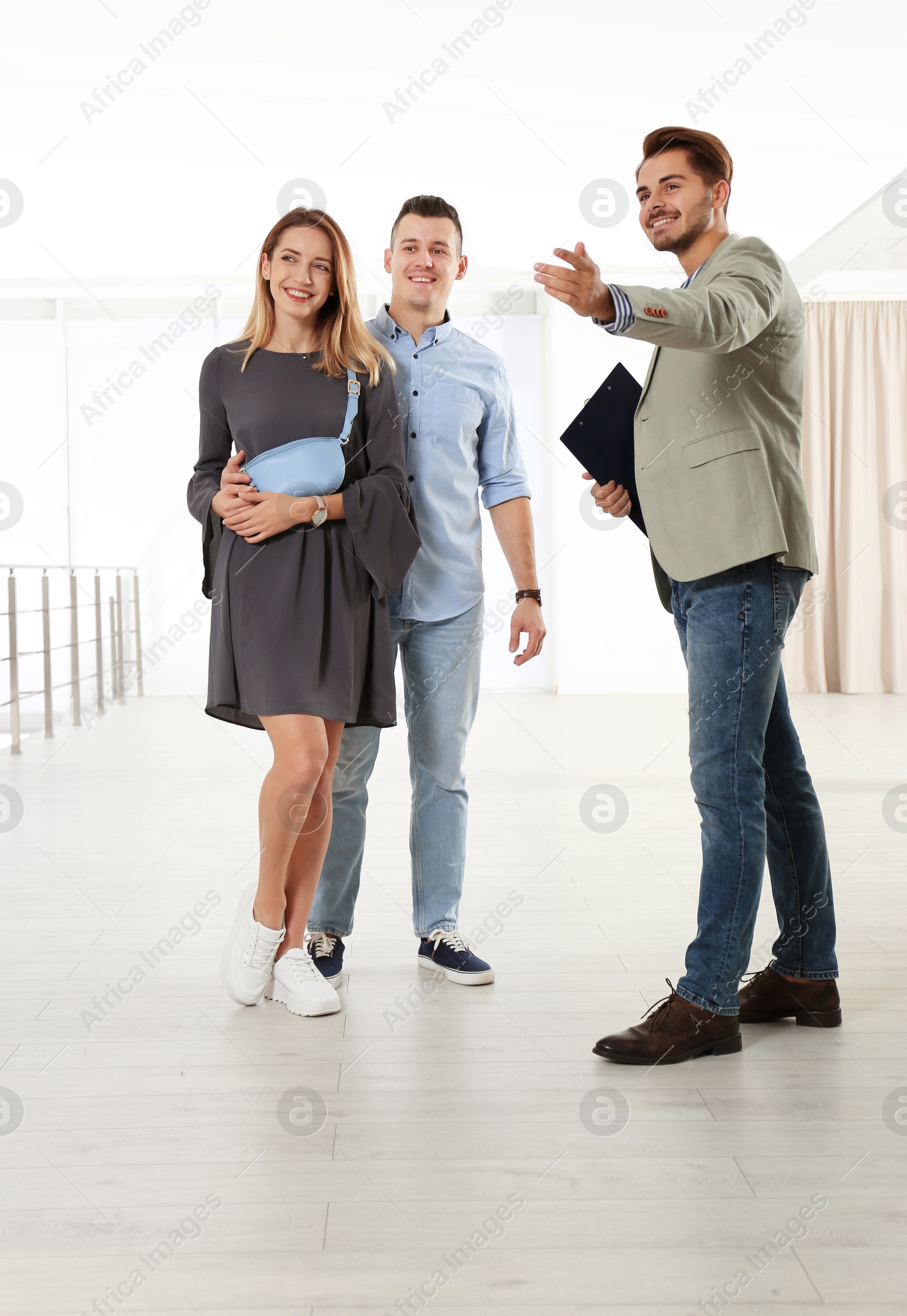 Photo of Real estate agent showing new apartment to young couple