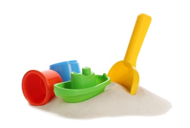 Plastic beach toys on pile of sand against white background