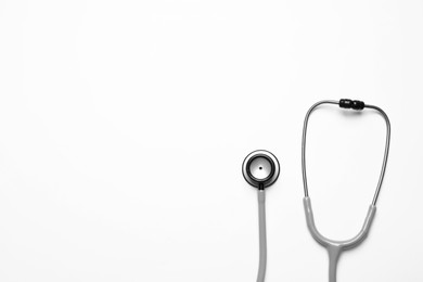 Stethoscope on white background, top view. Space for text