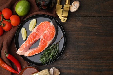 Photo of Fresh fish, products and marinade on wooden table, flat lay. Space for text