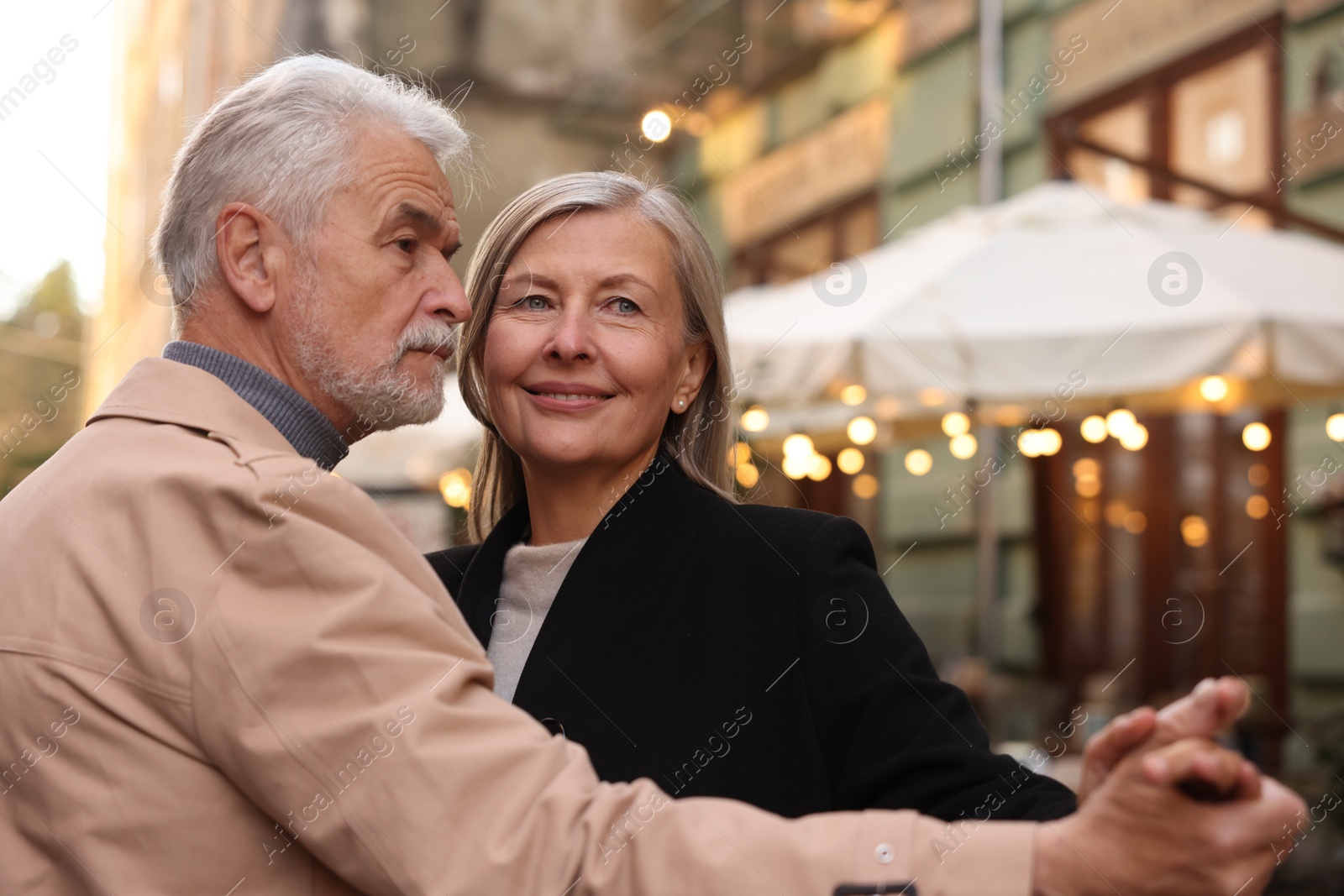 Photo of Affectionate senior couple dancing together on city street