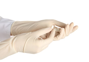 Doctor in medical gloves holding pills on white background