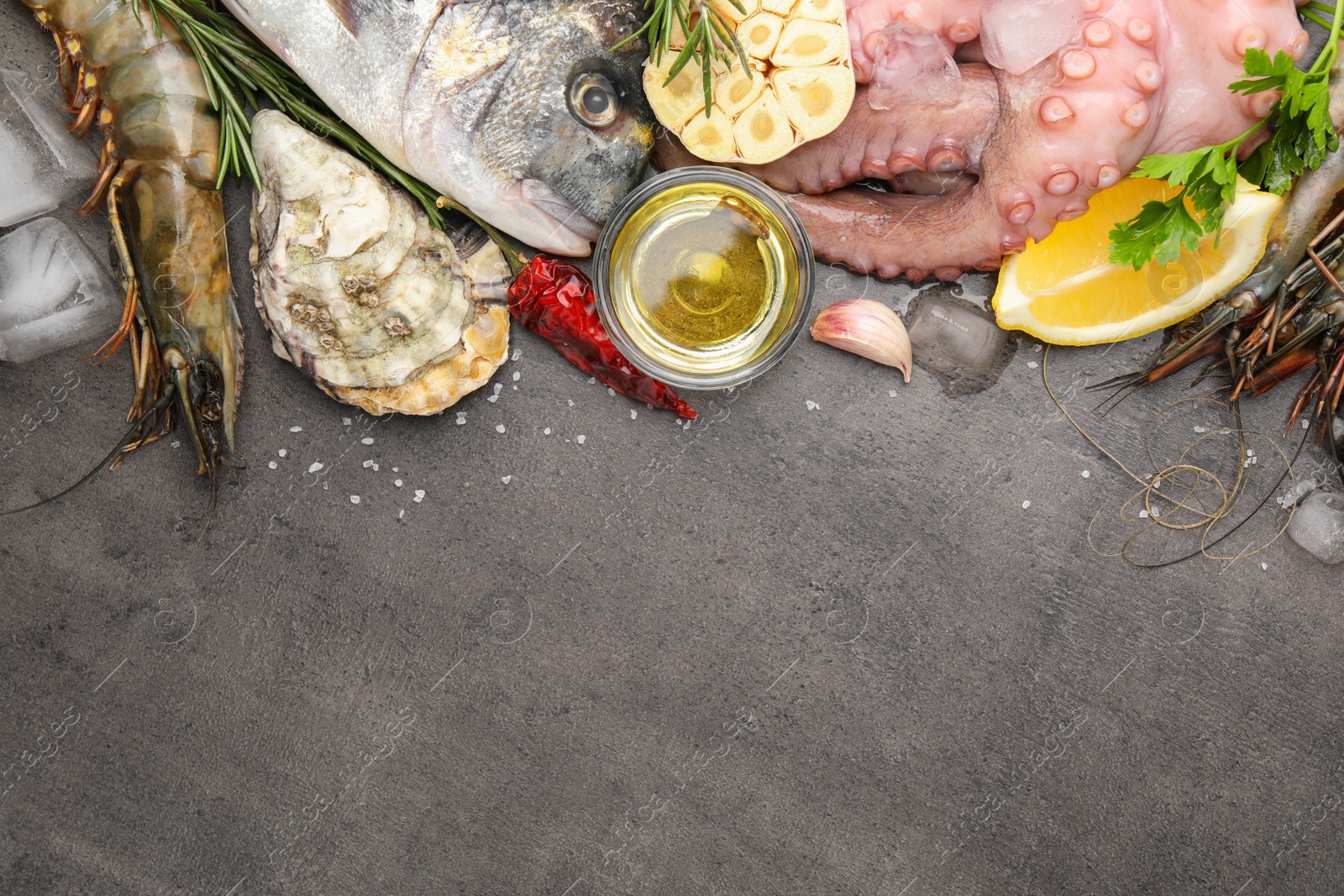 Photo of Flat lay composition with fresh raw dorado fish and different seafood on grey table. Space for text