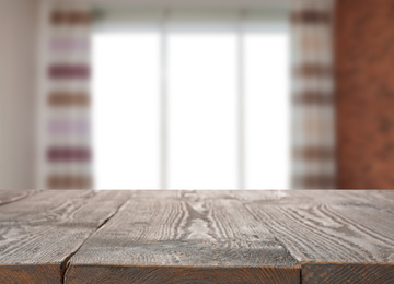 Image of Empty wooden surface and blurred view of modern window 