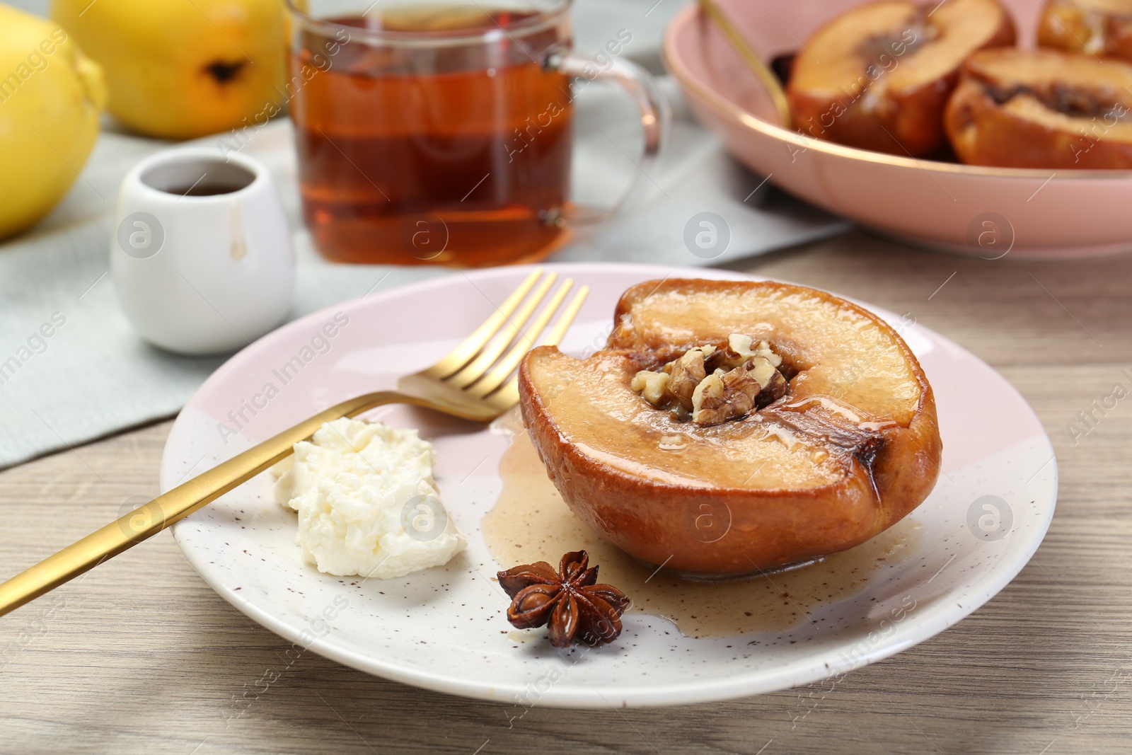 Photo of Delicious quince baked with honey and walnuts on wooden table