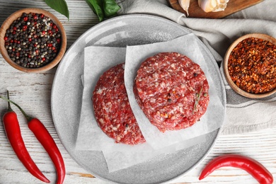 Flat lay composition with raw meat cutlets for burger on white wooden table