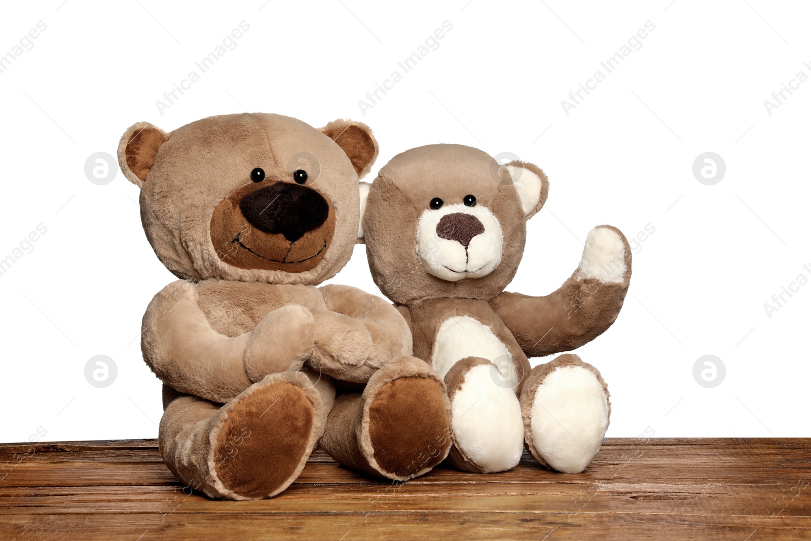 Photo of Cute teddy bears on wooden table against white background