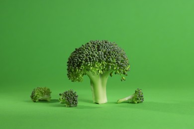 Fresh raw broccoli on light green background