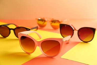 Photo of Stylish sunglasses on color background. Summer time