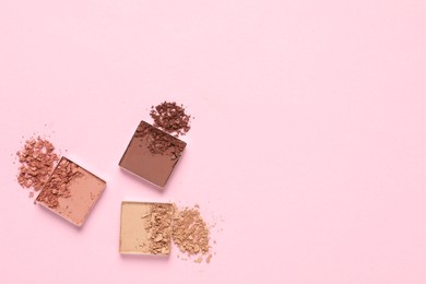 Photo of Crushed eye shadows on pink background, flat lay with space for text. Professional makeup product