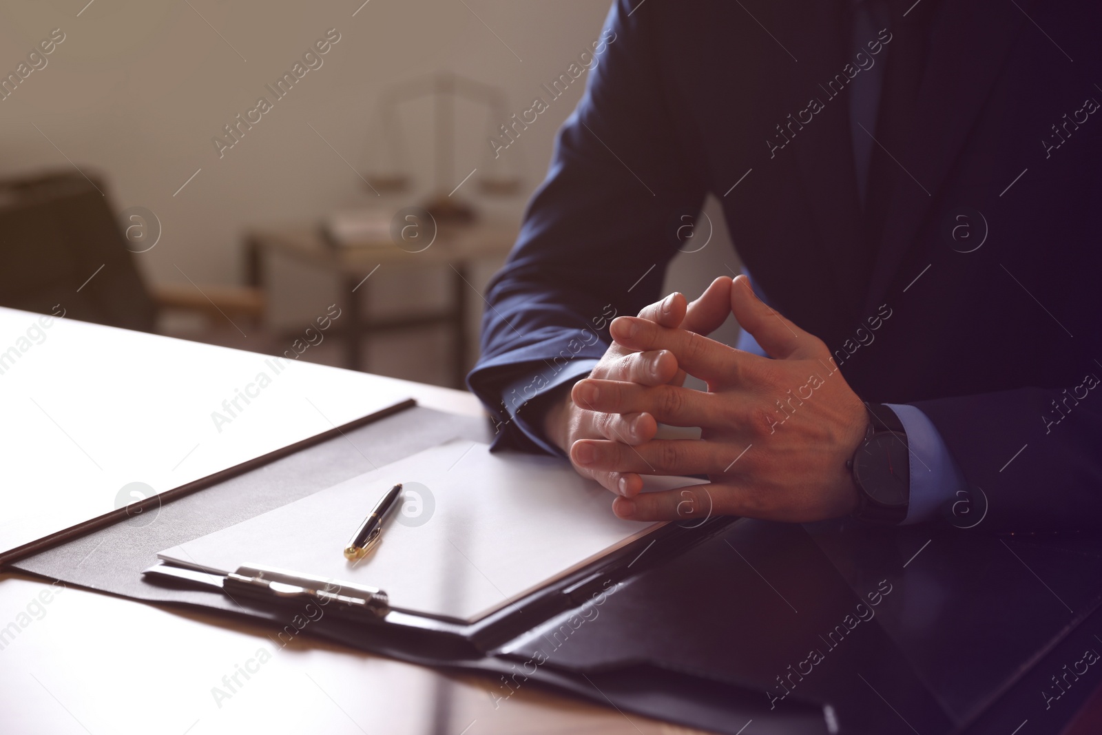 Photo of Male lawyer at table in office, closeup
