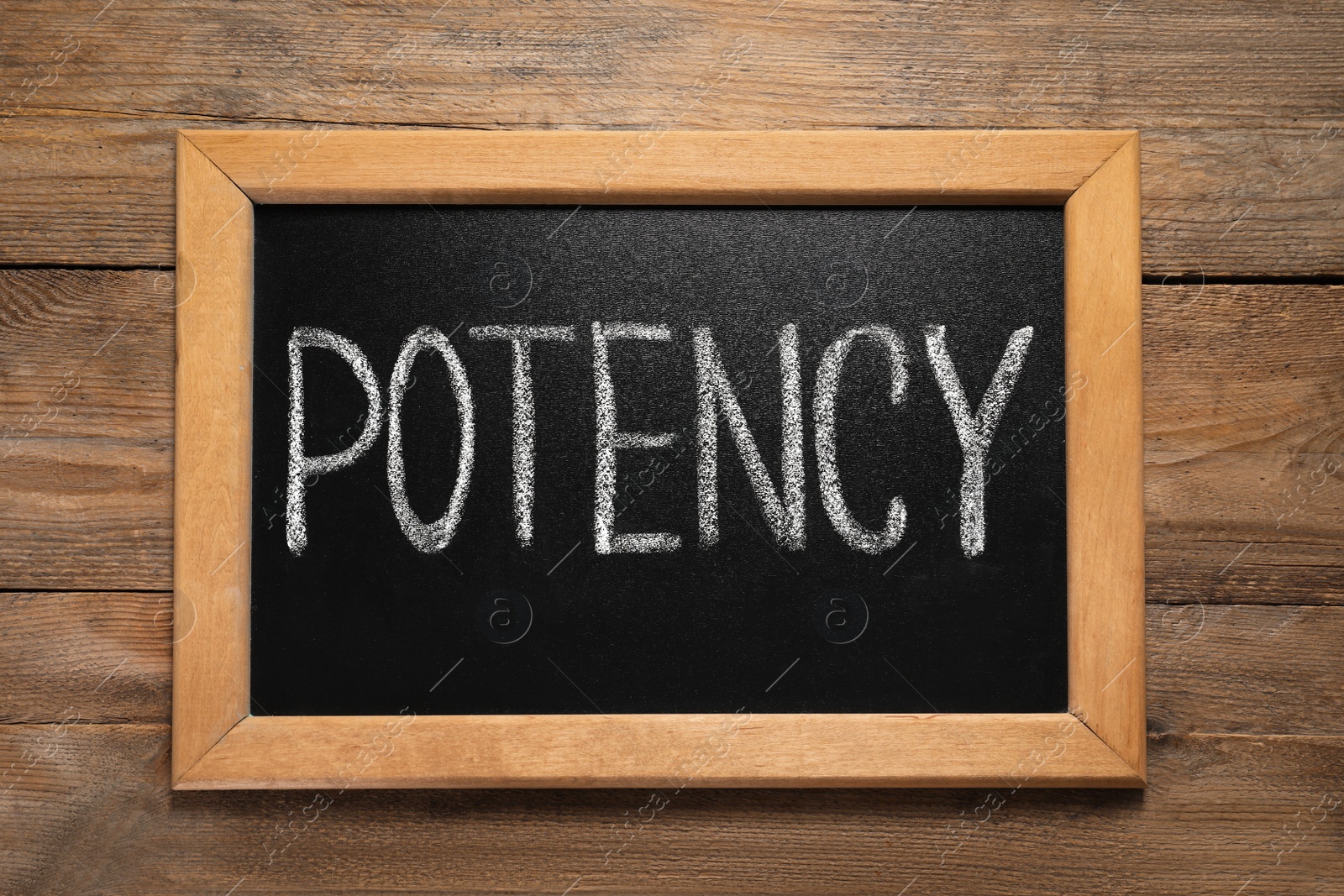 Photo of Blackboard with word Potency on wooden table, top view