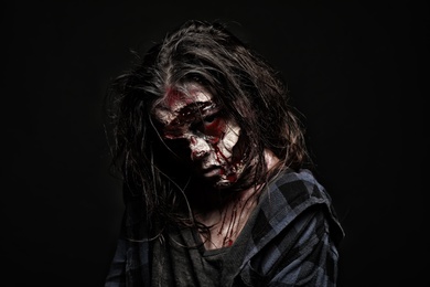 Photo of Scary zombie on dark background. Halloween monster