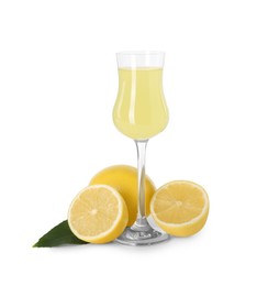 Photo of Liqueur glass with tasty limoncello, lemons and green leaf isolated on white
