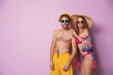 Happy young couple in beachwear on color background. Space for text