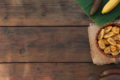 Photo of Tasty deep fried banana slices and fresh fruits on wooden table, flat lay. Space for text