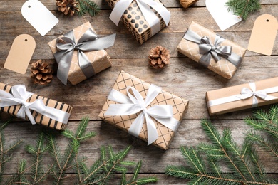 Photo of Flat lay composition with Christmas gifts and fir branches on wooden background