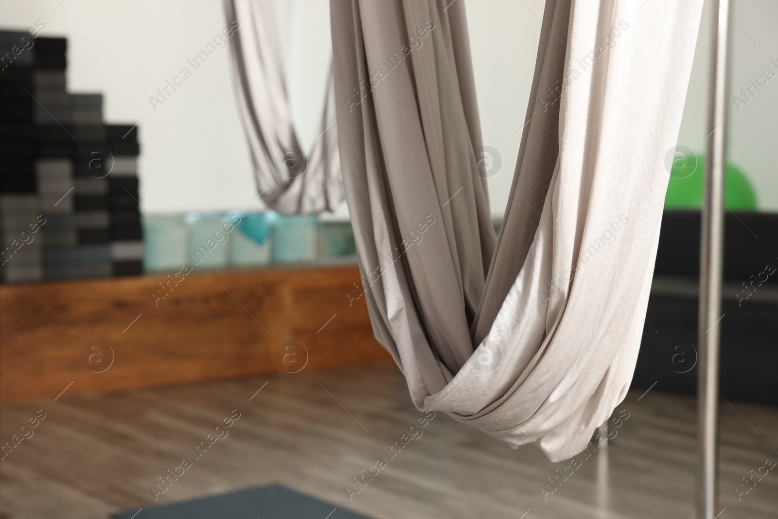 Photo of White hammocks for fly yoga in studio, closeup. Space for text
