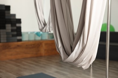 Photo of White hammocks for fly yoga in studio, closeup. Space for text