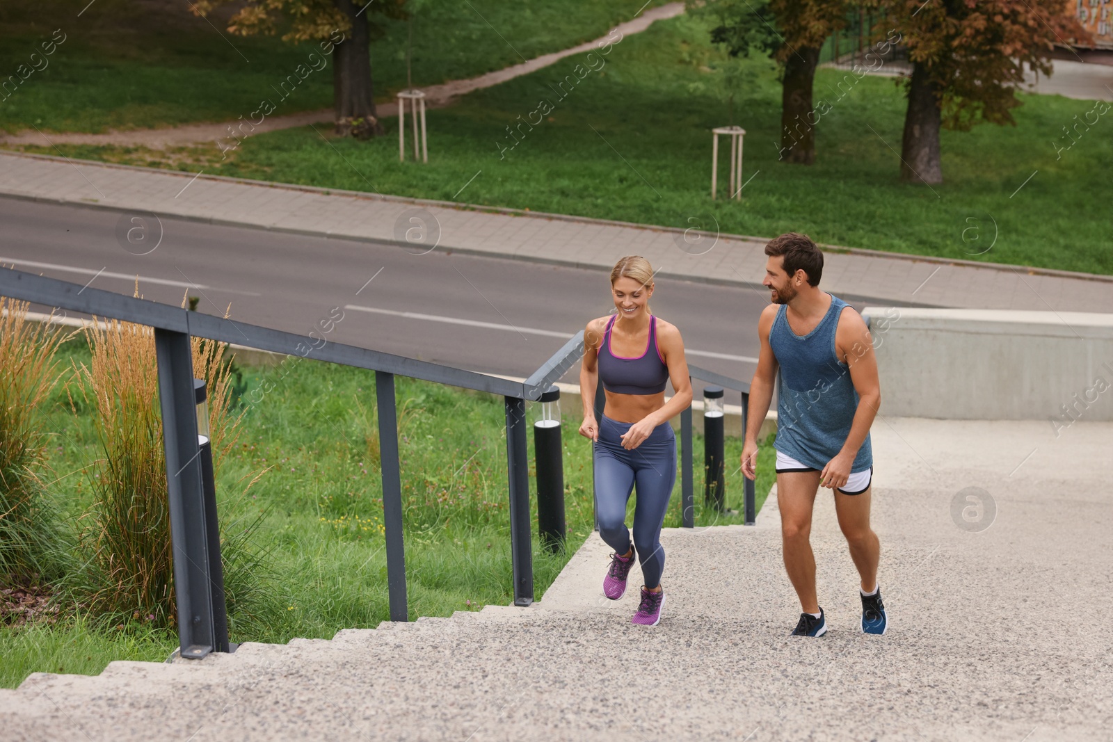 Photo of Healthy lifestyle. Happy couple running up stairs outdoors