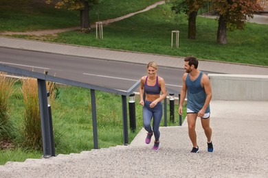 Healthy lifestyle. Happy couple running up stairs outdoors