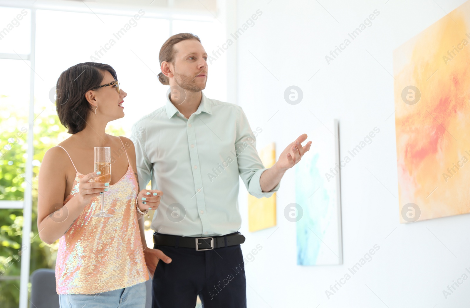 Photo of Young couple at exhibition in art gallery