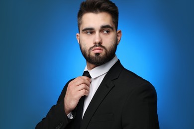 Photo of Handsome businessman in suit and necktie on blue background