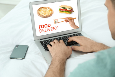 Man using laptop for online food order during quarantine, closeup. Delivery service