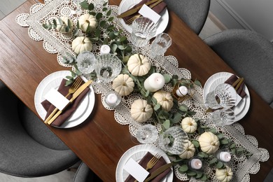 Beautiful autumn table setting. Plates, cutlery, glasses, blank cards and floral decor, flat lay