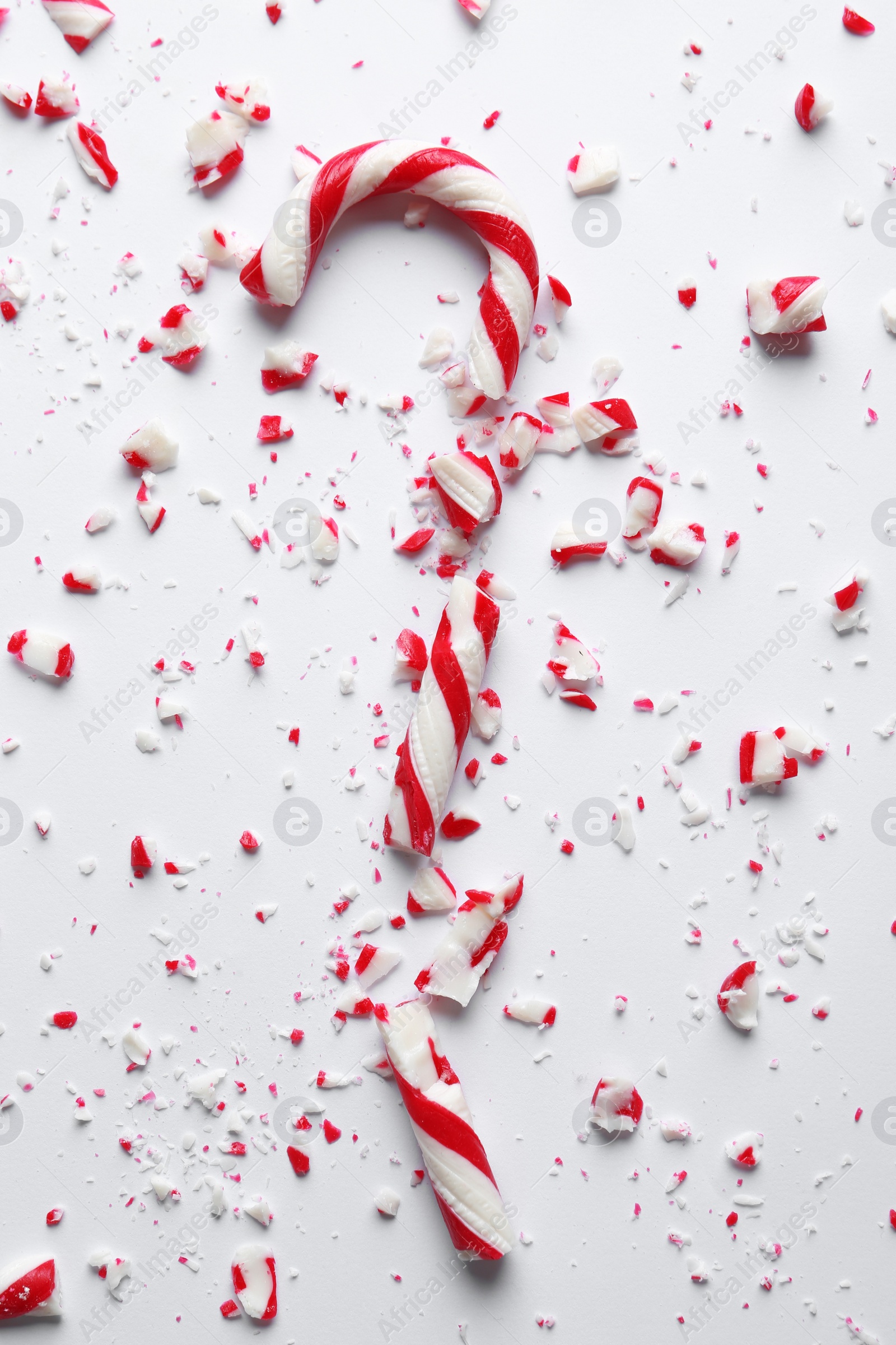 Photo of Crushed candy cane on white background, top view. Traditional Christmas treat