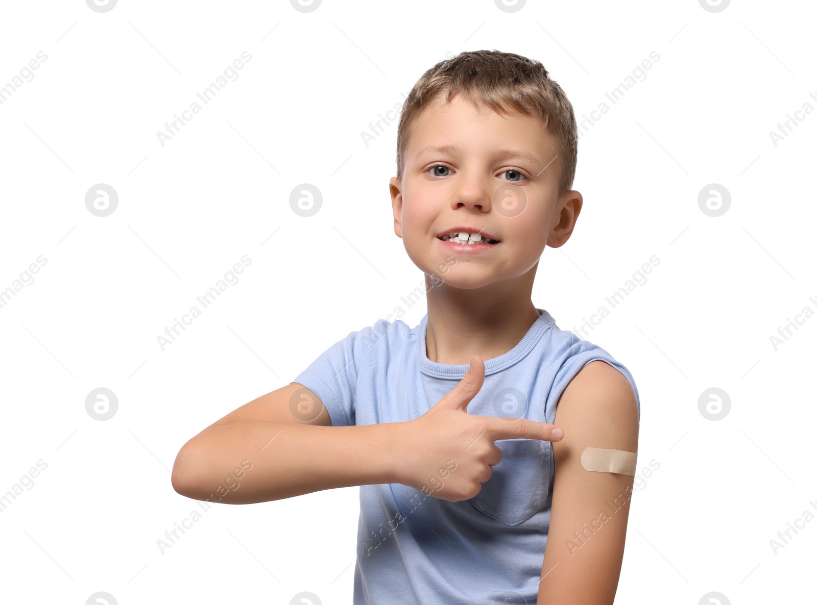 Photo of Boy pointing at sticking plaster after vaccination on his arm against white background