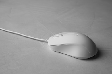 One wired mouse on grey textured table, closeup