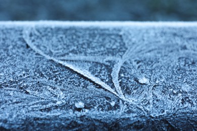 Plank covered with beautiful hoarfrost on blurred background, closeup