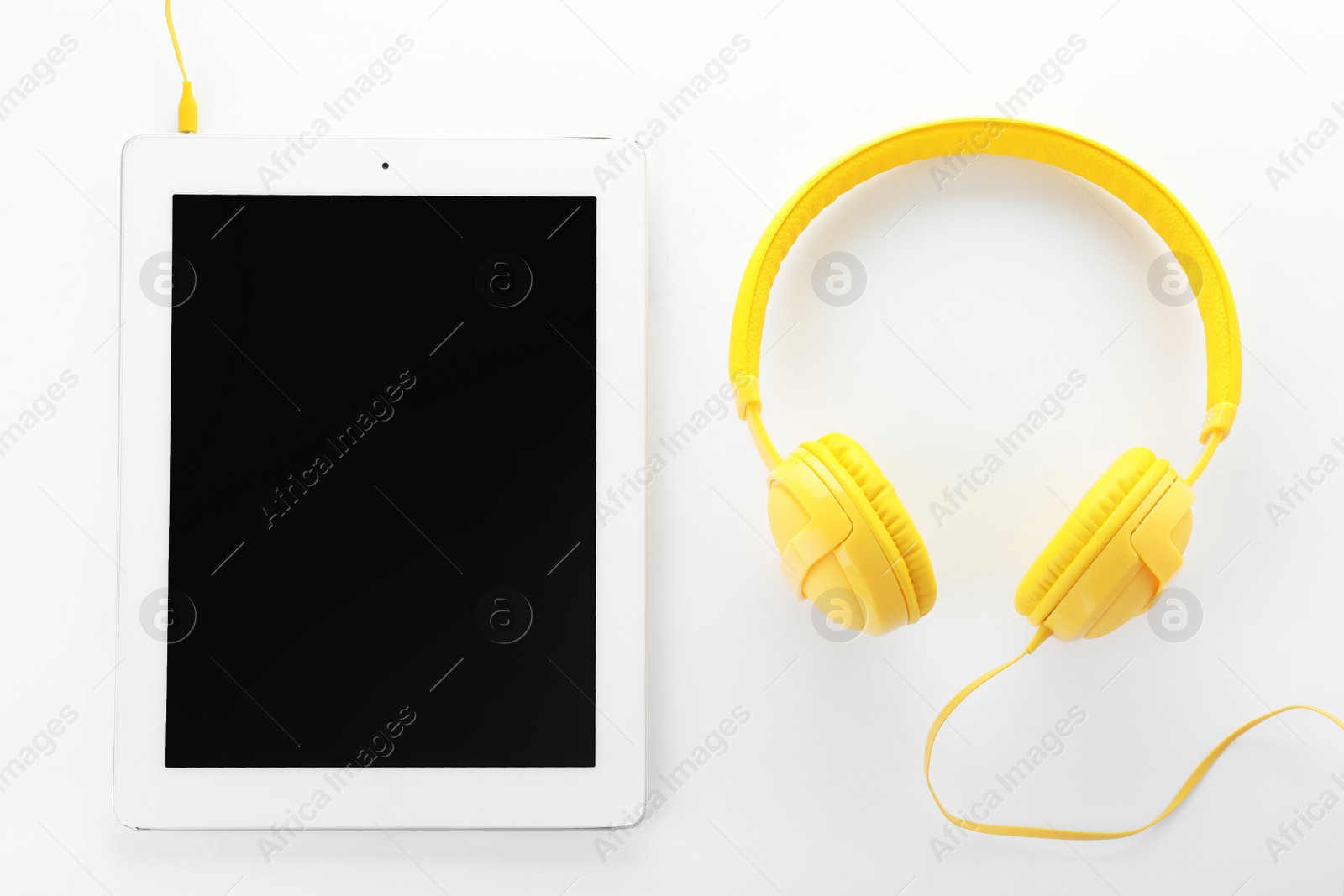 Photo of Tablet with blank screen and headphones on white background, top view