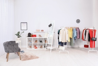 Photo of Light room interior with stylish clothes and shoes