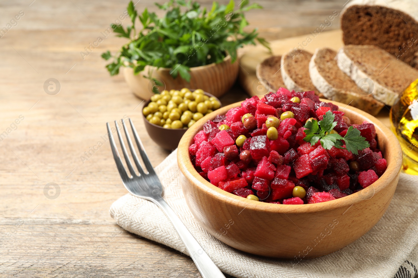 Photo of Traditional Russian salad vinaigrette served on wooden table. Space for text