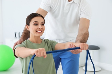 Professional physiotherapist working with female patient in rehabilitation center