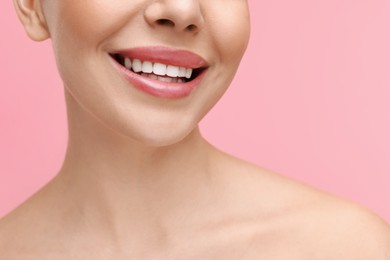 Photo of Woman with beautiful lips smiling on pink background, closeup