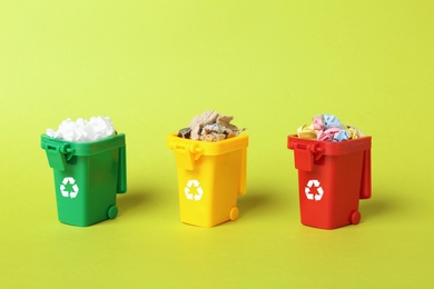 Trash bins and different garbage on color background. Waste recycling concept