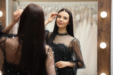 Photo of Woman trying on dress in clothing rental salon