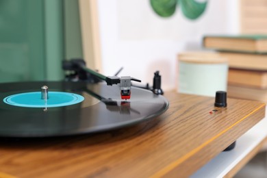 Stylish turntable with vinyl record indoors, closeup. Space for text