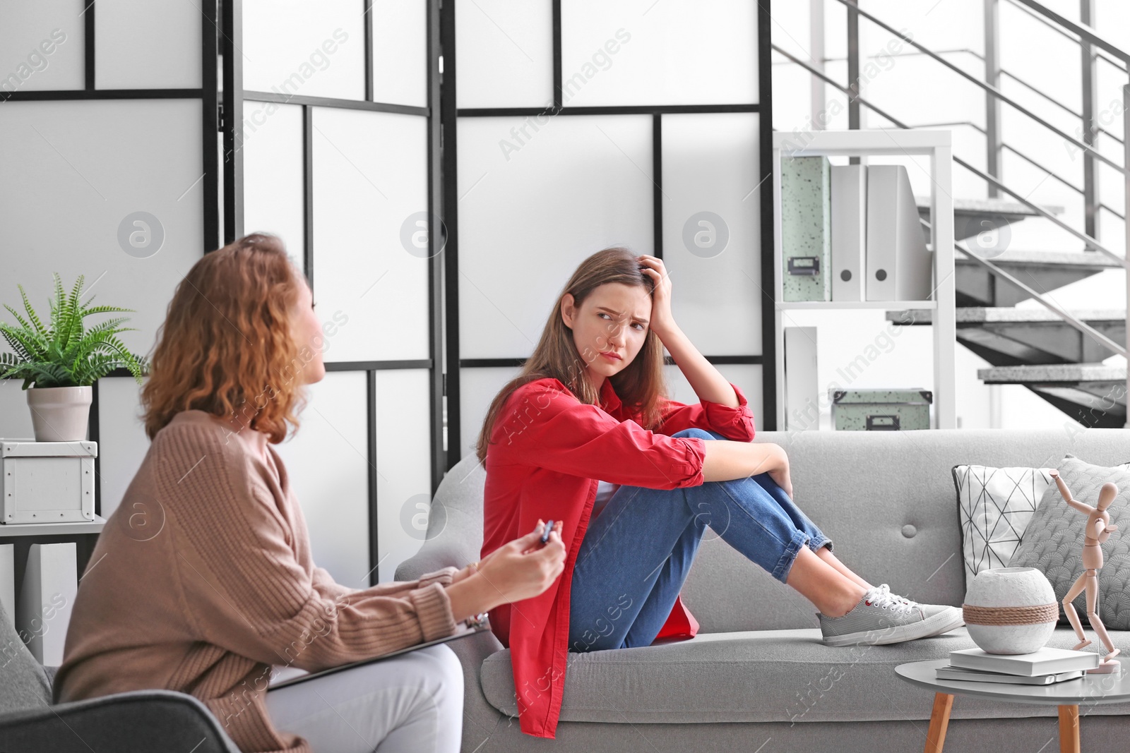 Photo of Child psychologist working with teenage girl in office