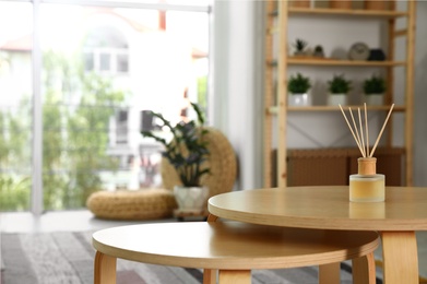 Photo of Reed diffuser on wooden table in modern room interior