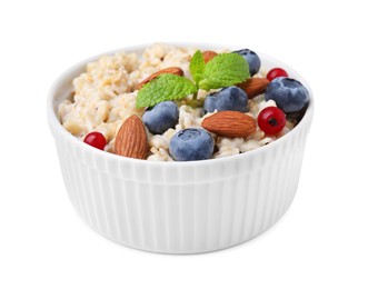 Ceramic bowl with oatmeal, berries. almonds and mint isolated on white