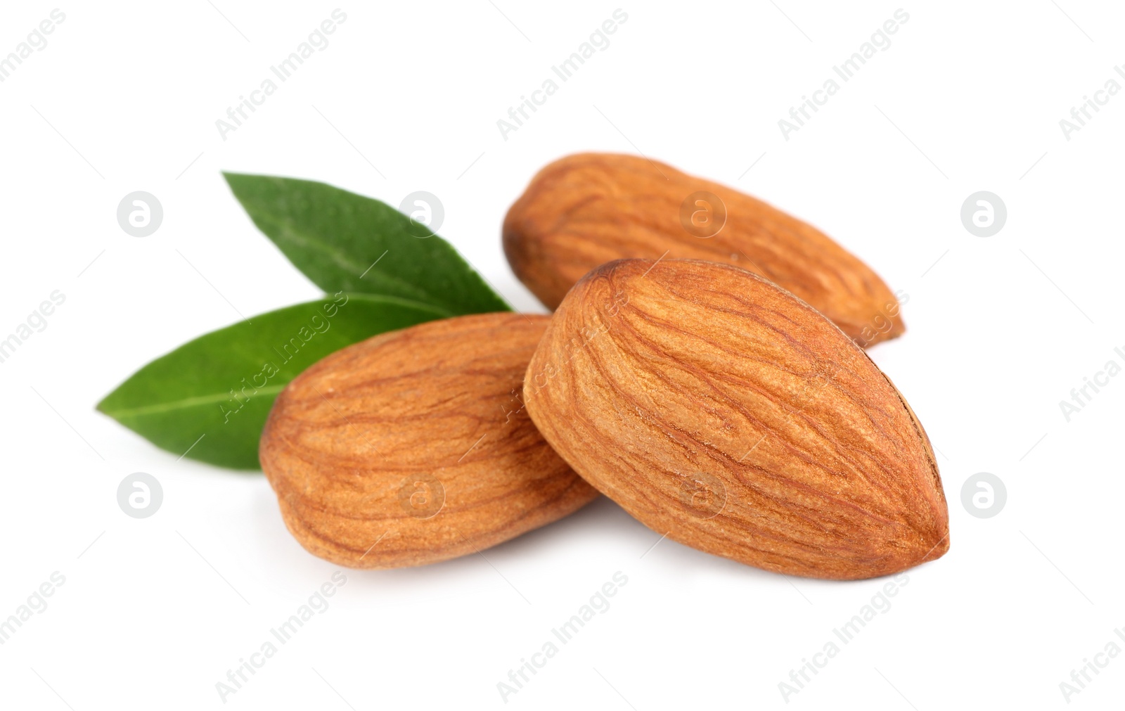 Photo of Organic almond nuts and green leaves on white background. Healthy snack