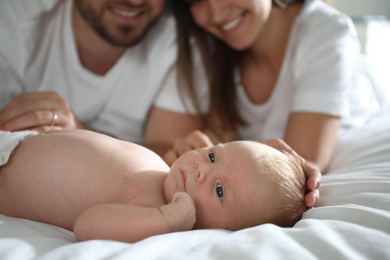 Newborn baby lying near parent on bed, closeup