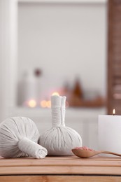 Photo of Spa composition with burning candle and herbal bags on massage table in wellness center, space for text
