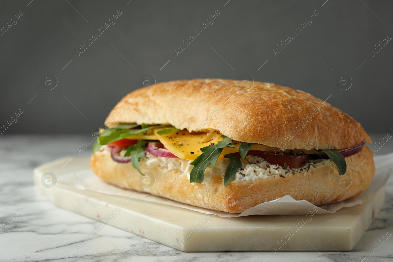 Photo of Delicious sandwich with fresh vegetables and cheese on white marble table