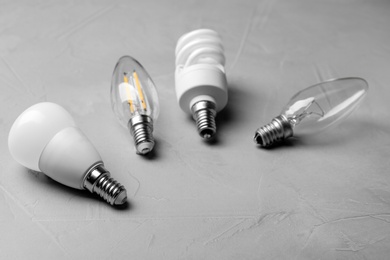 Photo of Different lamp bulbs on grey stone background