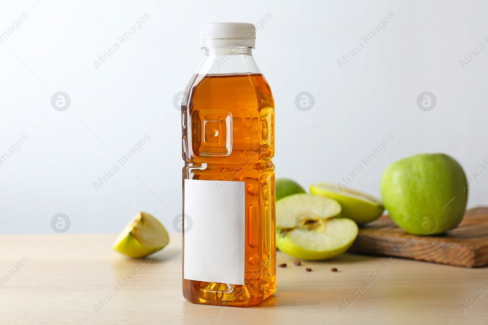 Photo of Bottle of fresh apple juice on wooden table